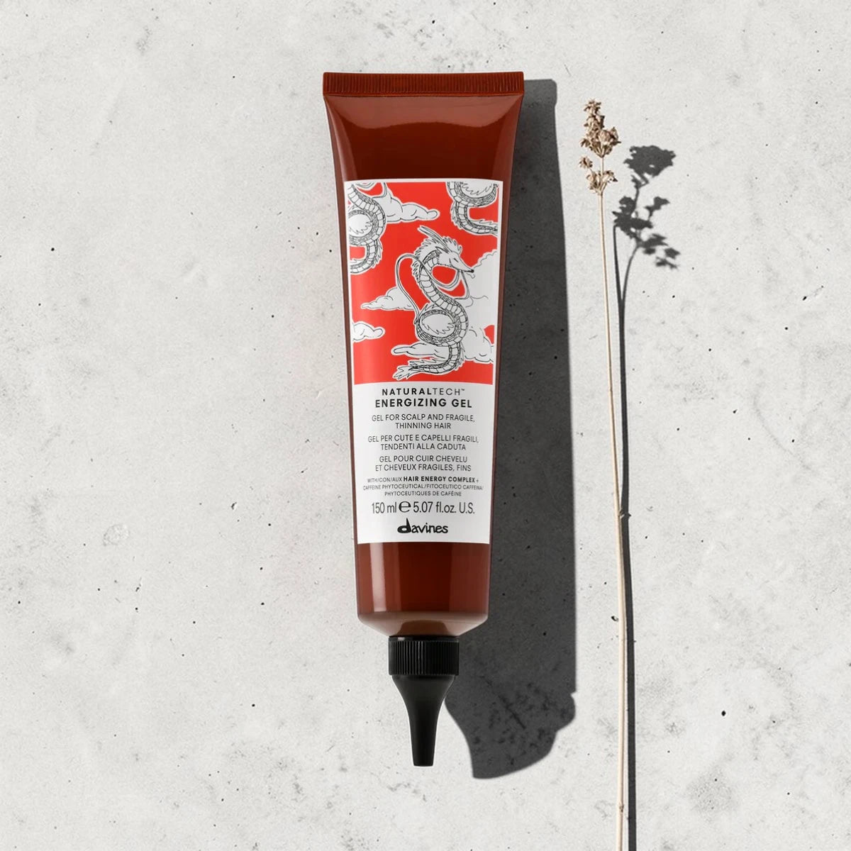 Tube de produit capillaire Davines sur un fond gris texturé