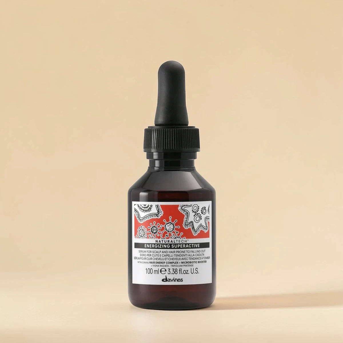 Bouteille de produit capillaire Davines avec un compte-gouttes sur un fond beige
