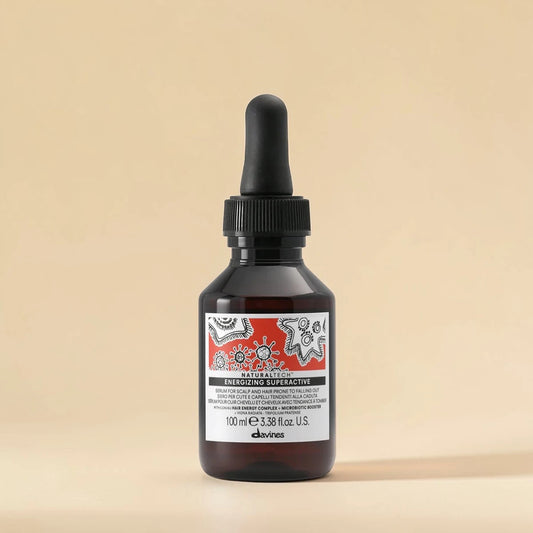 Bouteille de produit capillaire Davines avec un compte-gouttes sur un fond beige