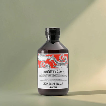 Bouteille de shampooing énergisant Davines Naturaltech sur un fond dégradé