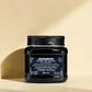 Pot noir de davines Heart of Glass conditionneur sur un fond beige