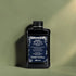Bouteille de shampooing noir avec étiquette bleue sur un fond vert
