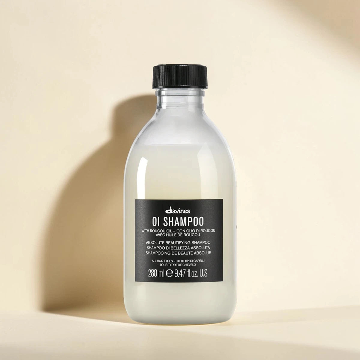 Bouteille de shampooing étiquetée '0I Shampoo' par Davines sur fond beige