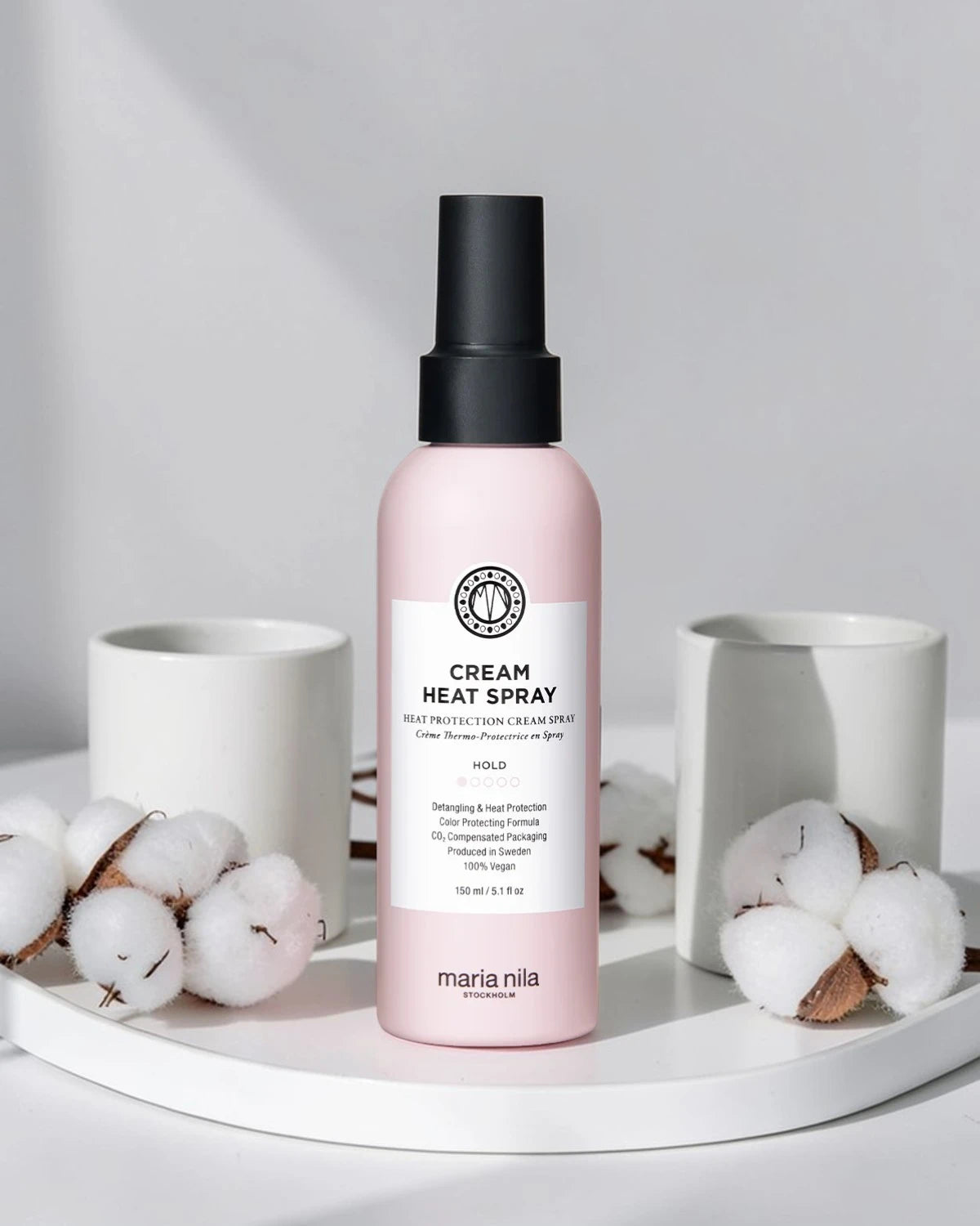 Spray thermoprotecteur Maria Nila Cream Heat Spray sur plateau blanc avec coton et tasses blanches, Victor Bazin Paris