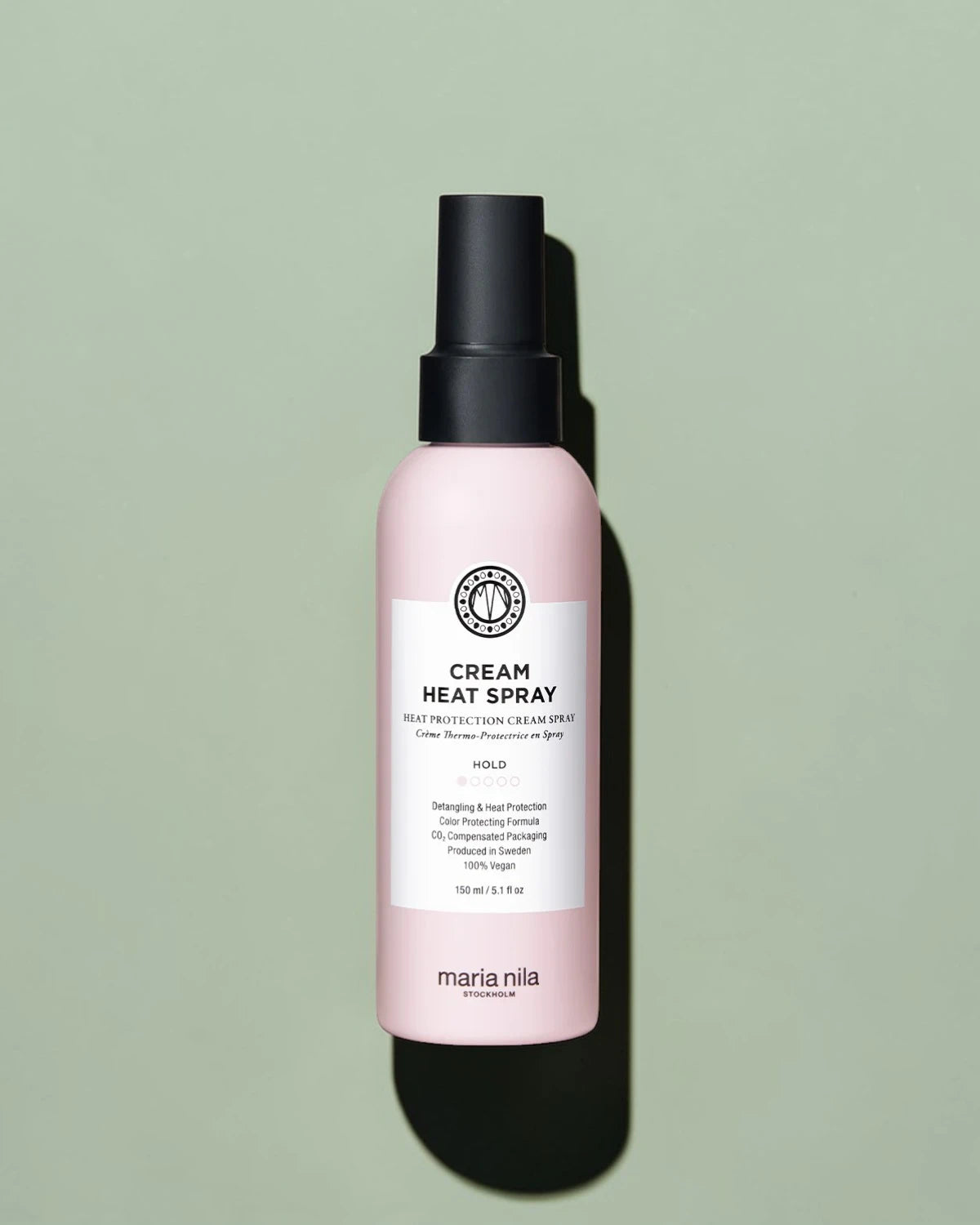 Flacon de spray chauffant crème avec étiquette rose sur fond vert clair