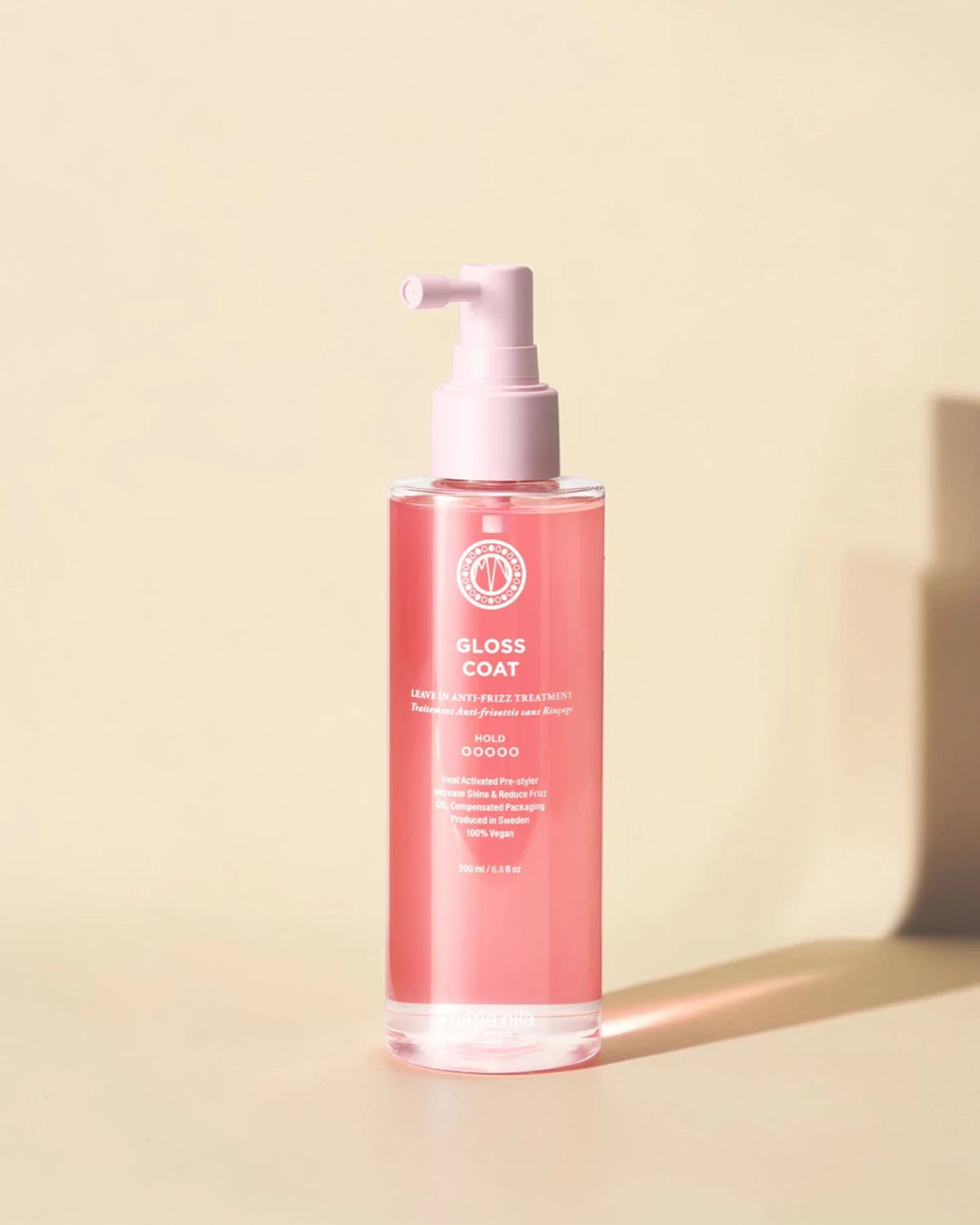 Bouteille de produit 'Gloss Coat' sur fond beige