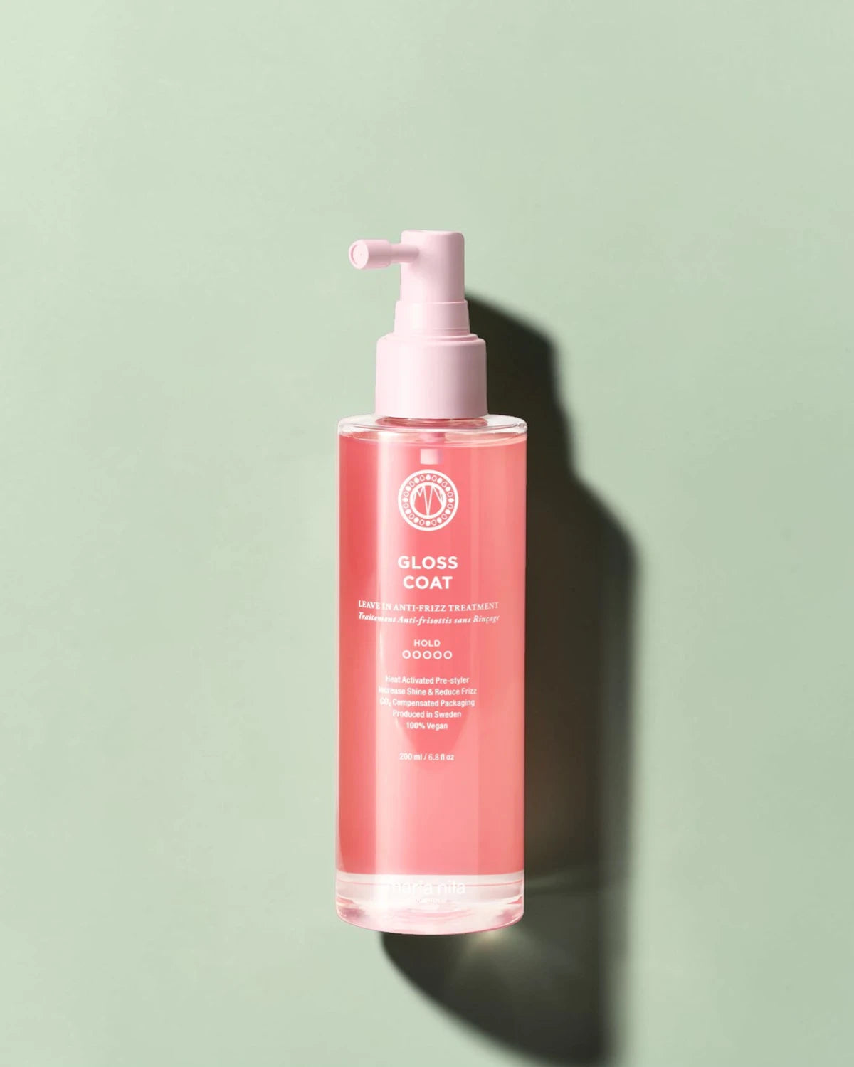 Bouteille rose avec pompe sur un fond vert clair