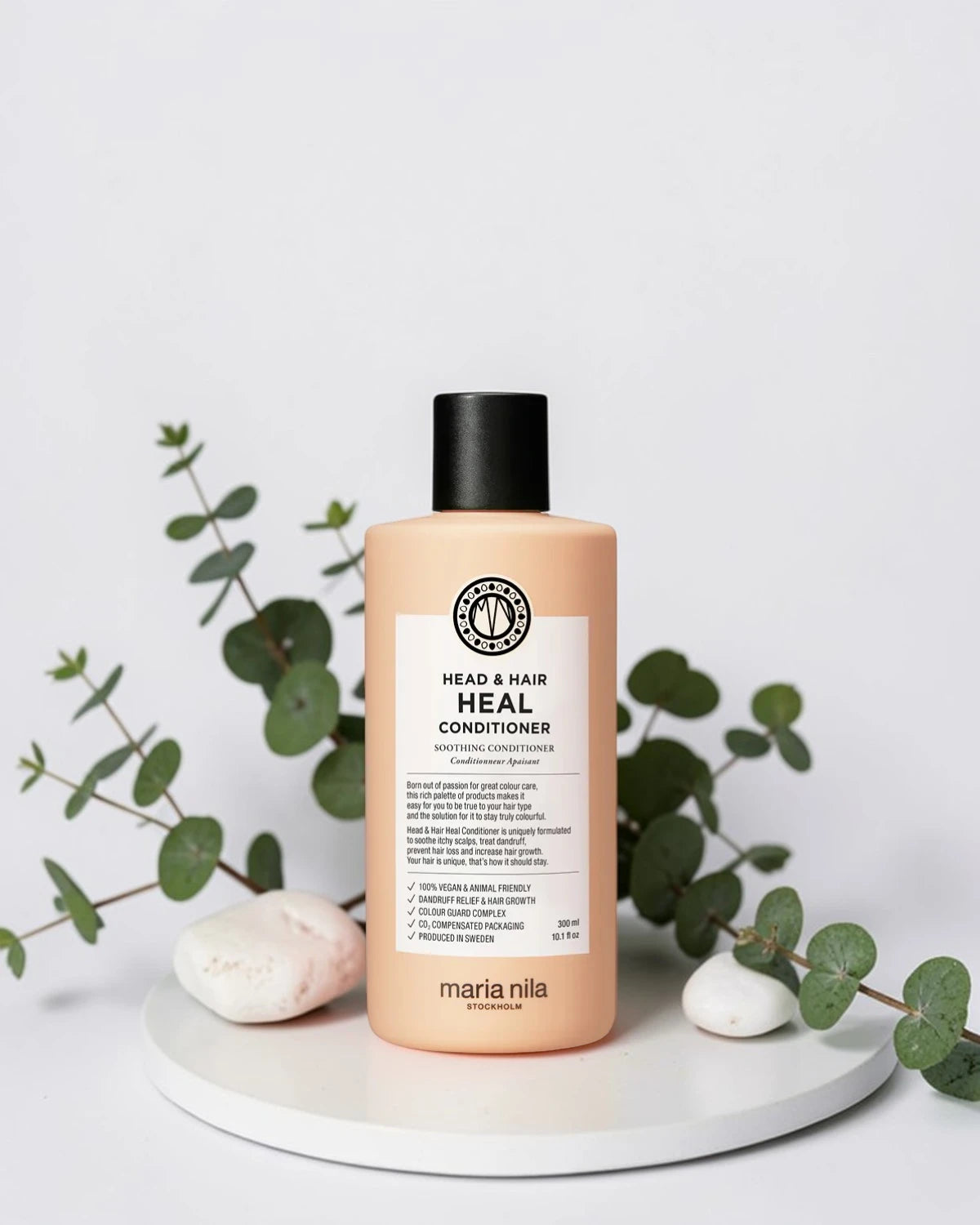 Après-shampoing Maria Nila Head & Hair Heal Conditioner sur plateau blanc avec eucalyptus et galets, Victor Bazin Paris