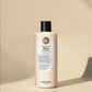 Bouteille de shampooing Maria Nila sur fond beige