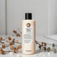 Shampoing Maria Nila Head & Hair Heal sur fond gris clair avec fleurs séchées et galets blancs, Victor Bazin Paris