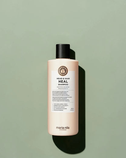Bouteille de shampooing étiquetée 'Head & Hair Heal' par Maria Nila sur un fond vert