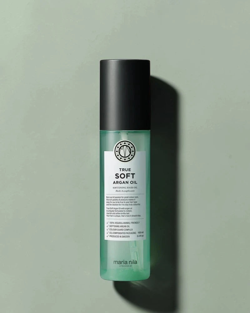 Bouteille verte d’huile d’argan True Soft de Maria Nila sur un fond vert clair