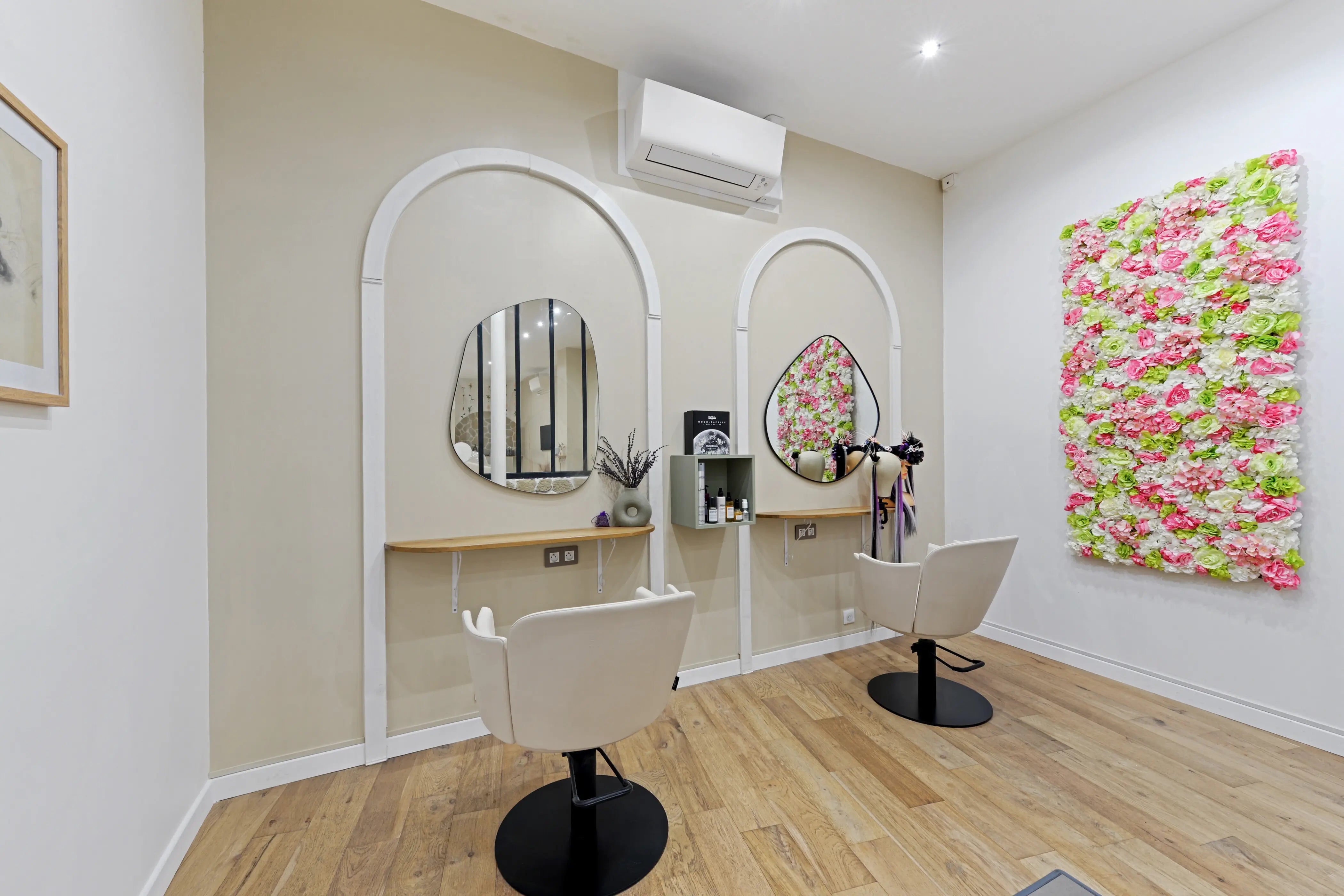 Salon de coiffure Victor Bazin Paris, postes de coiffage avec miroirs en arche et mur floral, Paris 17e