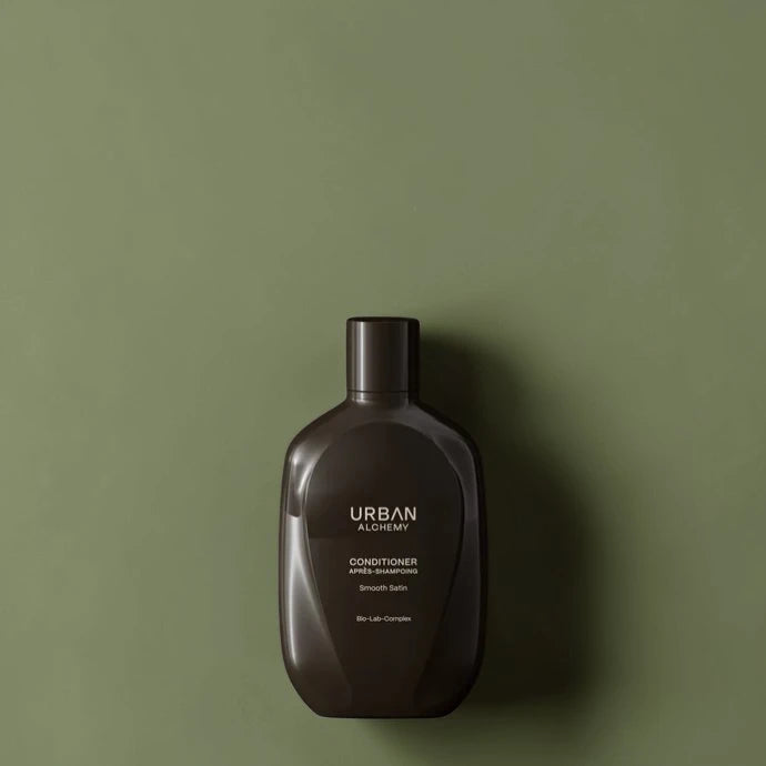 Flacon d’après-shampoing marron foncé avec marque 'Urban' sur fond vert